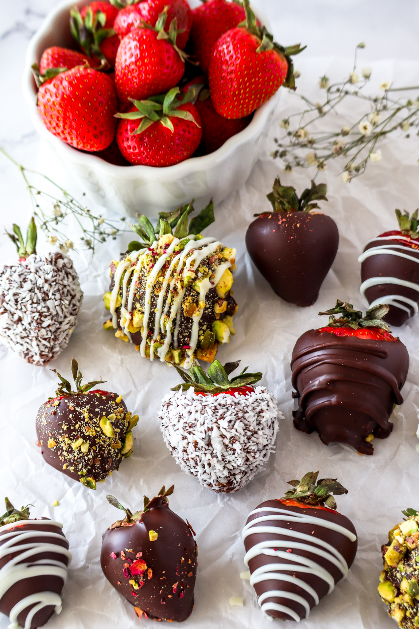 homemade chocolate covered strawberries rolled in shredded coconut and crushed pistachio