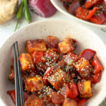 two bowls of chili paneer, topped with sesame seeds for garnish